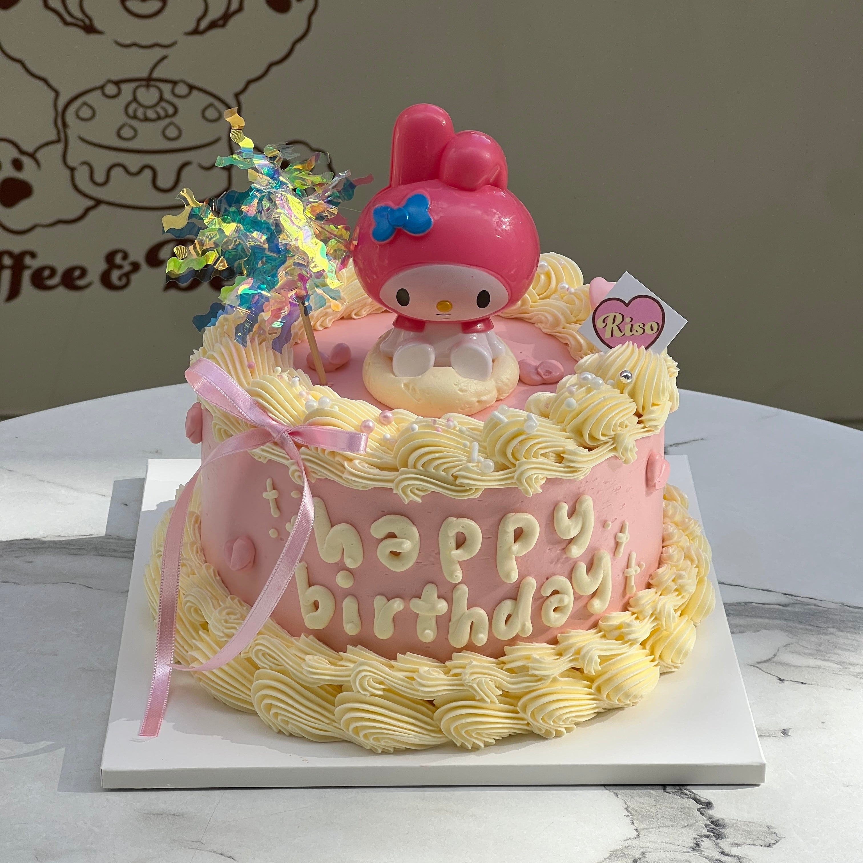 Close-up of the My Melody cake showing detailed piping, ribbon accents, and the 3D character figure on top