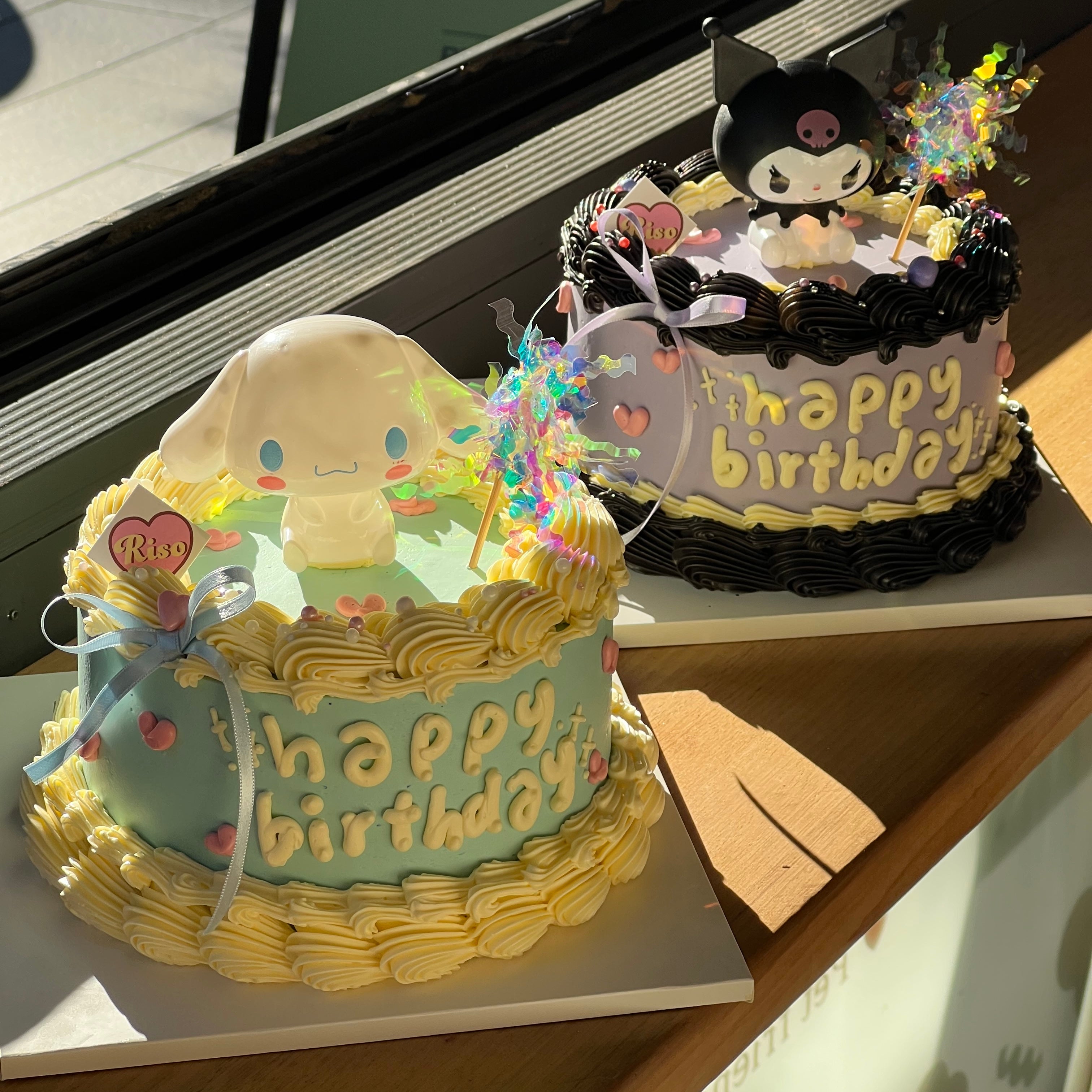 A blue birthday cake with a 3D Cinnamoroll figure, piped yellow frosting, and heart decorations
