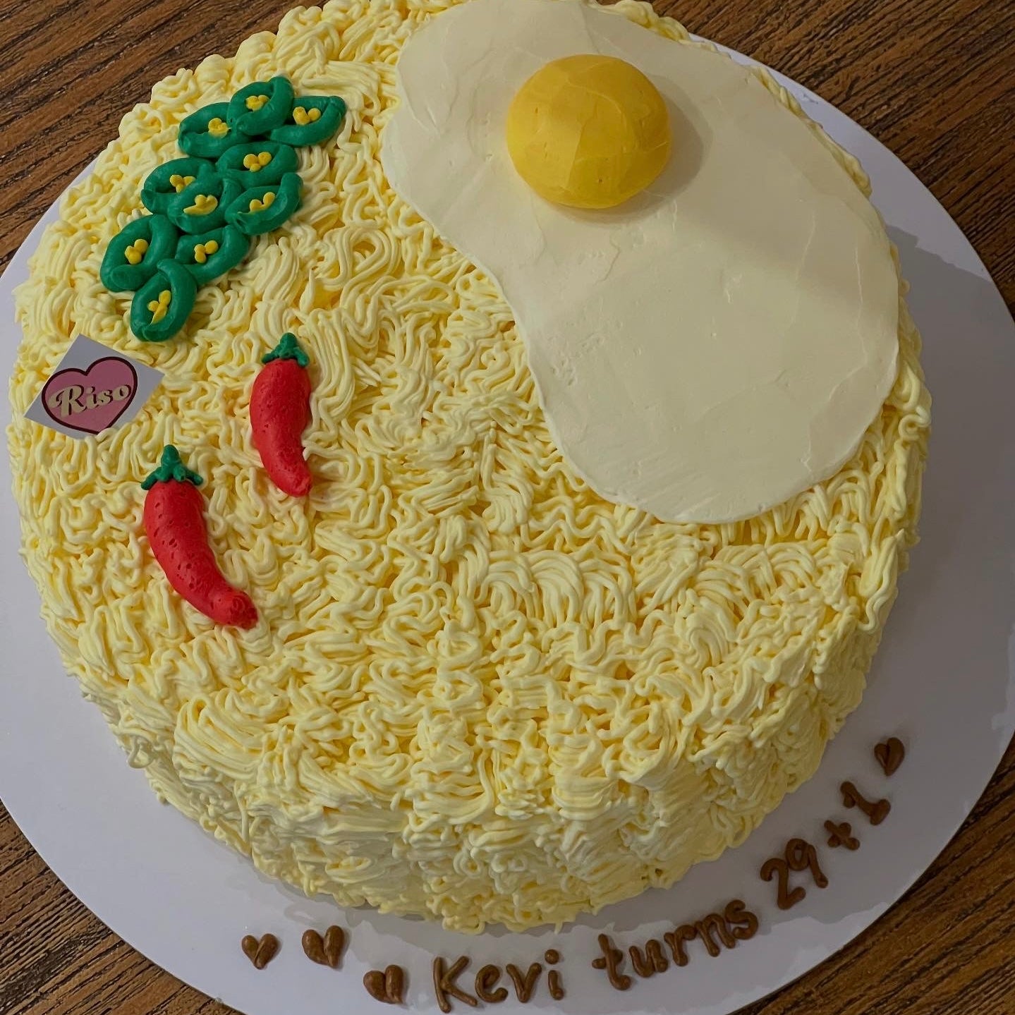 Top view of a unique ramen-style cake with detailed buttercream noodles and vibrant icing toppings