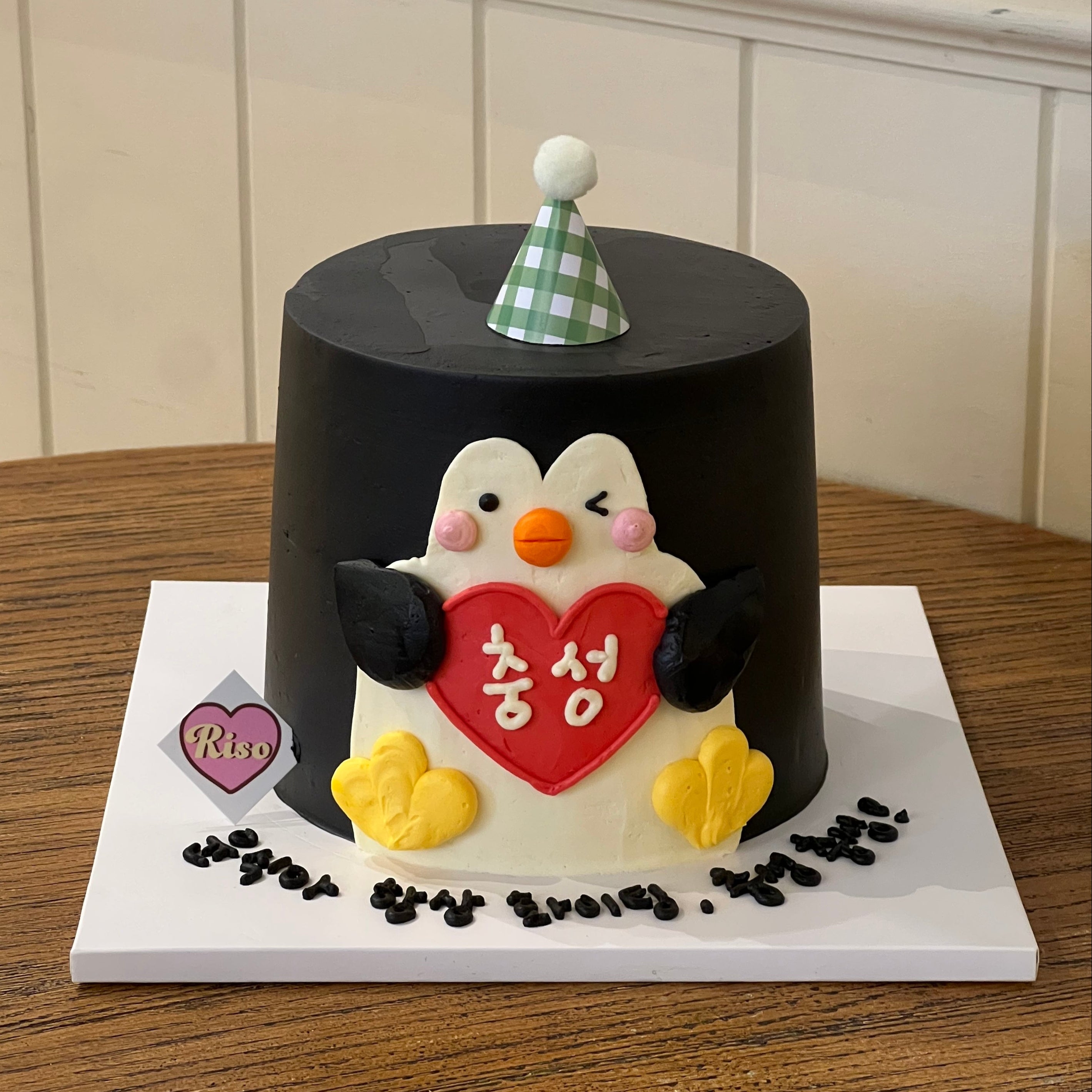 Penguin-themed 3D cake with a cute penguin figure holding a heart