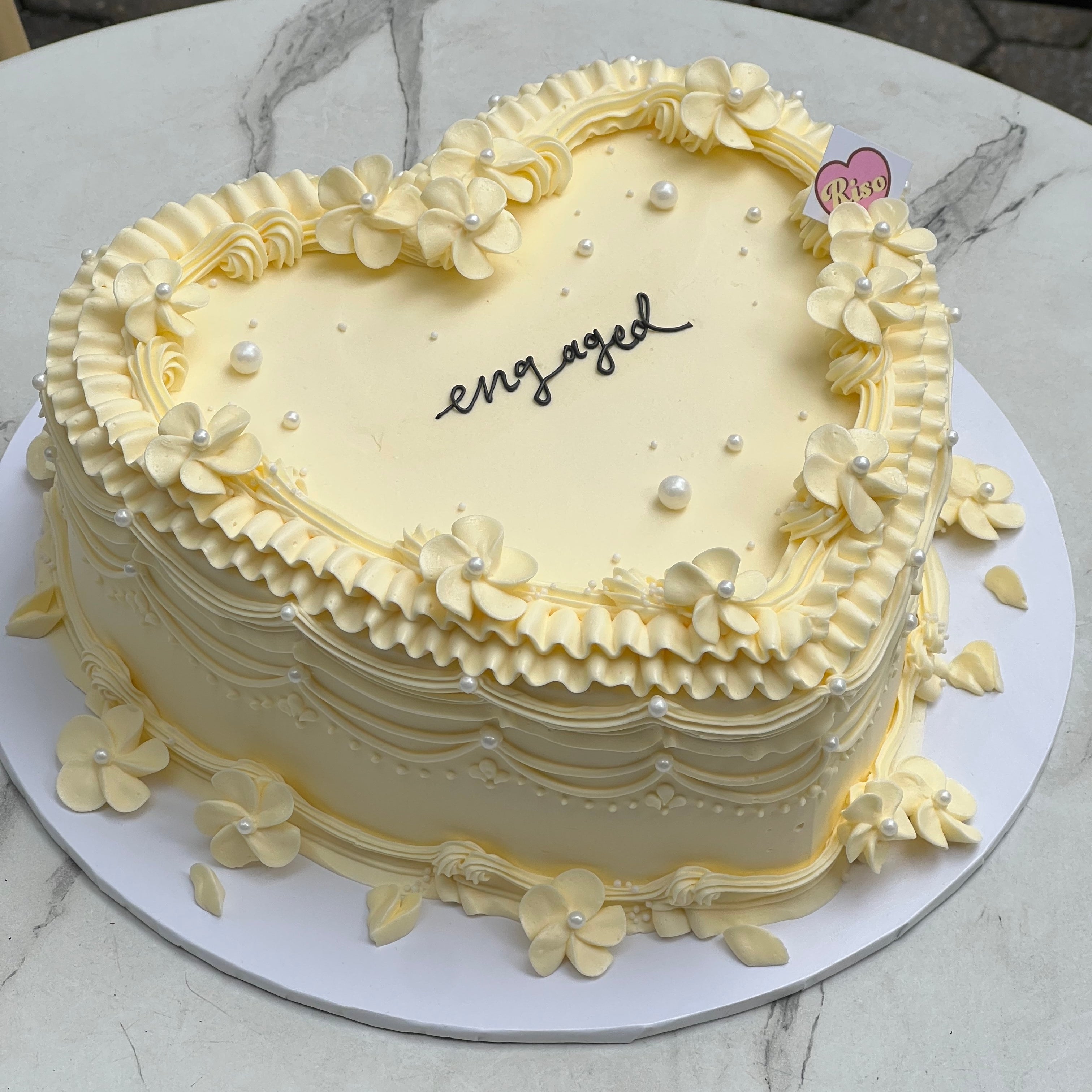 Vintage heart cake with cherry blossom-style buttercream flowers and edible pearls