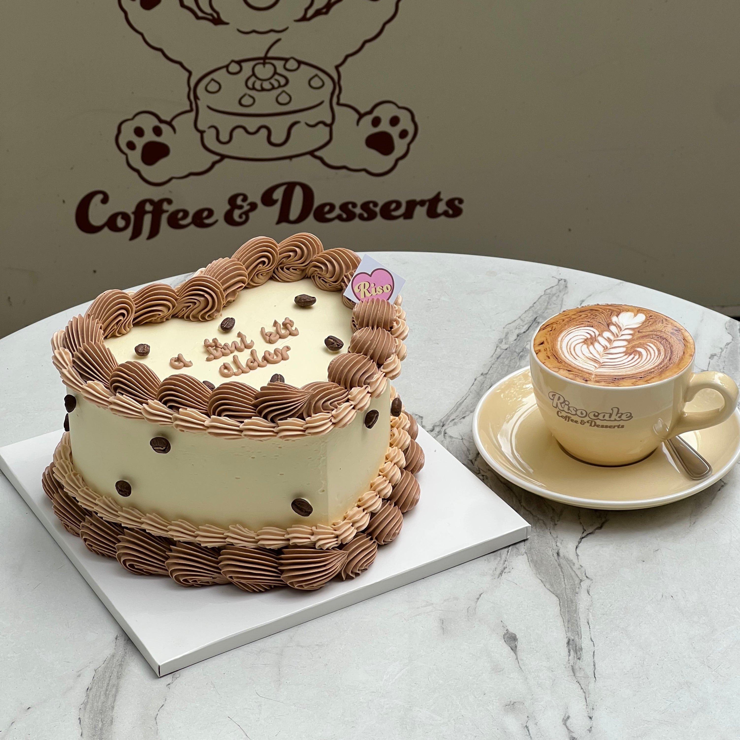 Adorable fake coffee cake with playful brown frosting swirls and a cheeky message “but still cute” ☕️💛