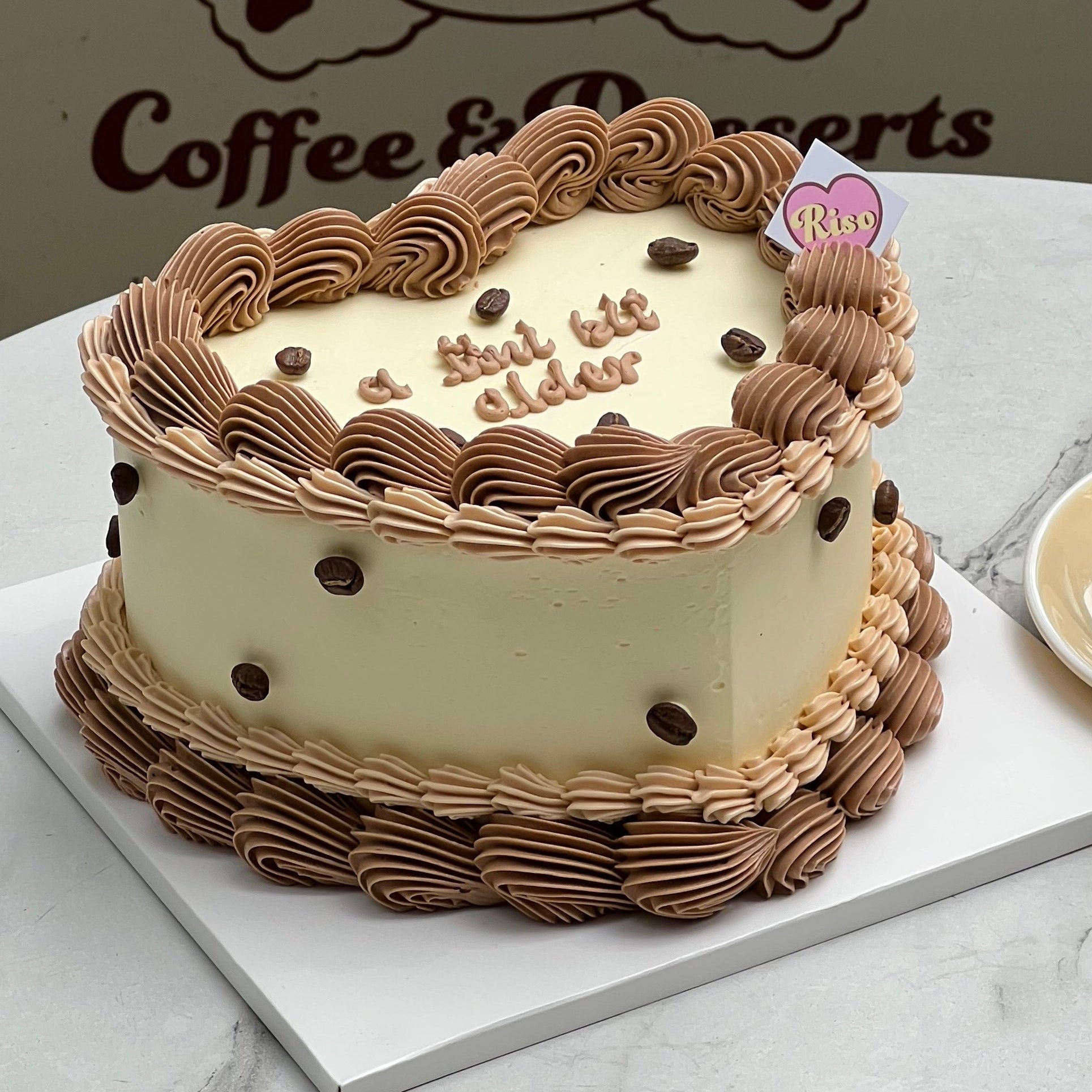 Cute coffee-themed heart cake with mocha swirl icing and faux chocolate coffee beans (not coffee flavoured)