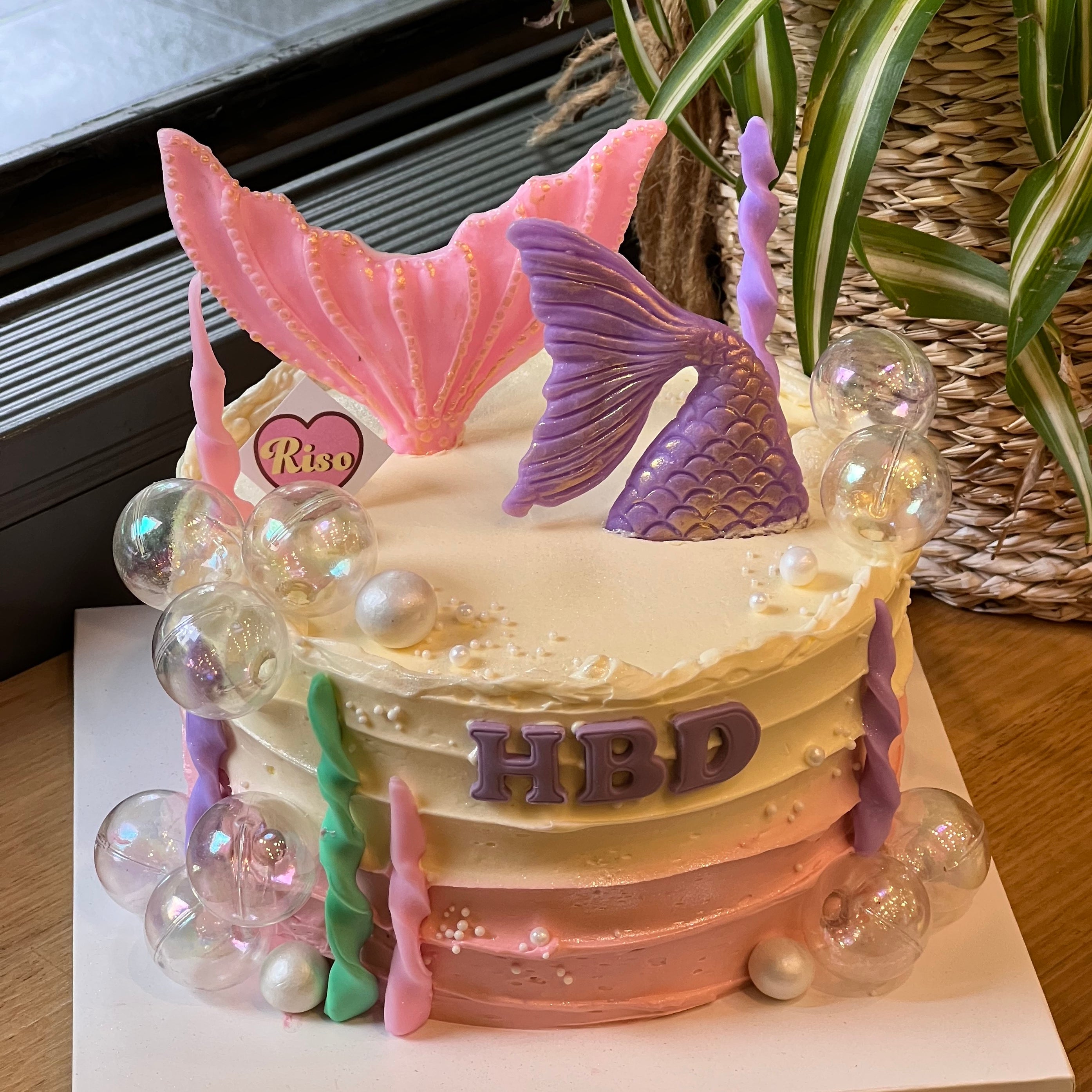 Mermaid cake for girls’ birthday parties, topped with pastel tails, ocean pearls, and bubble toppers