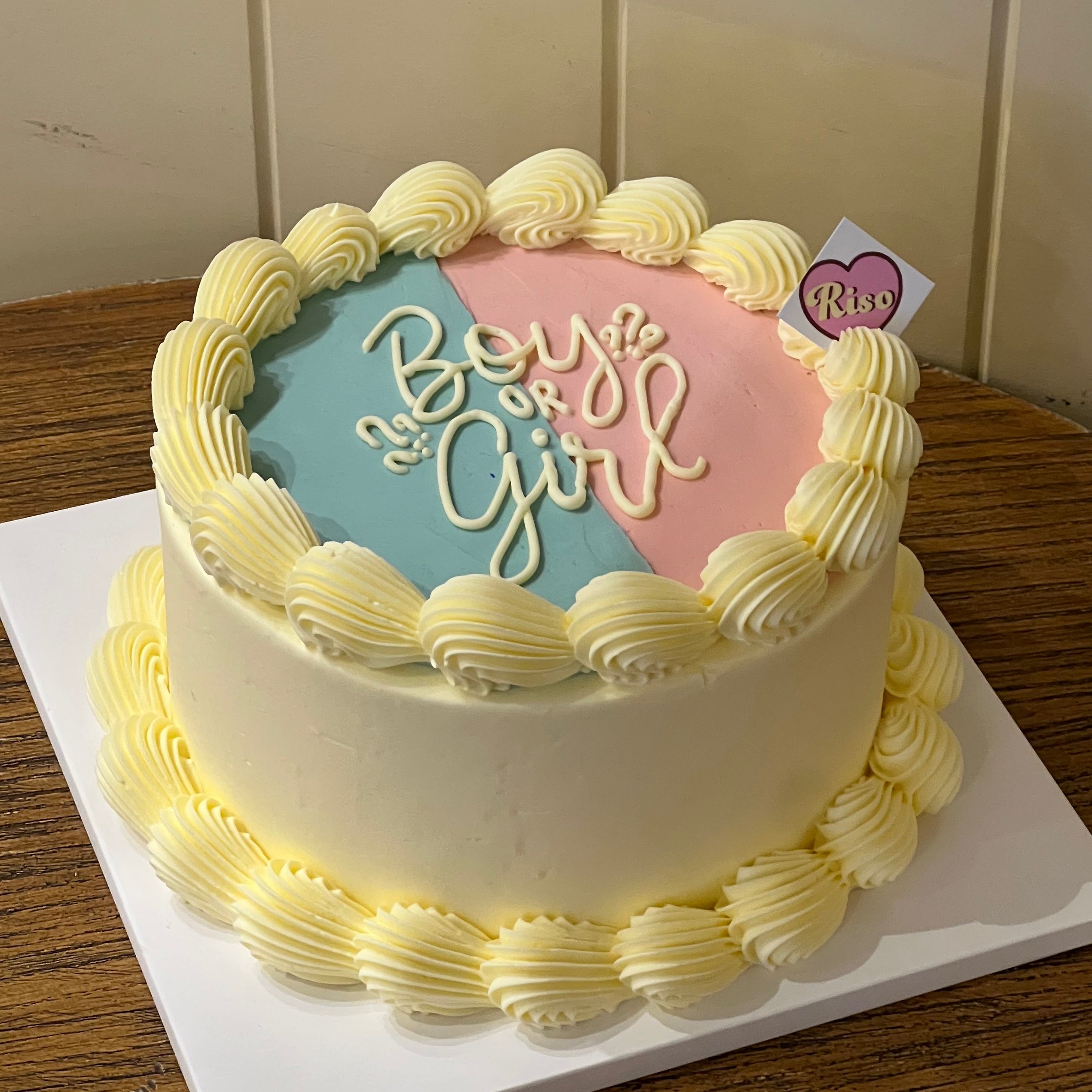 Gender reveal cake with pastel pink and blue frosting and hidden colored cream inside