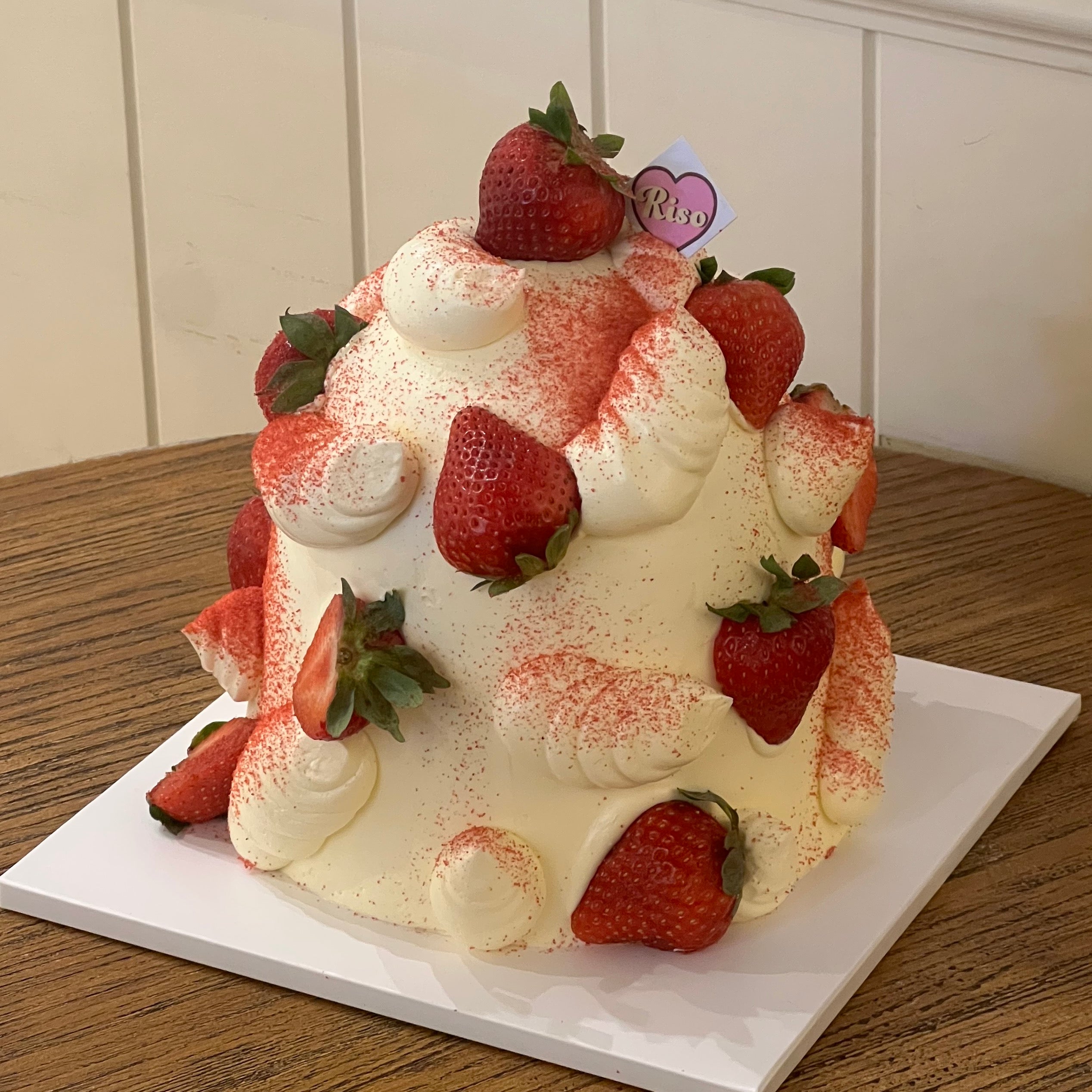 Strawberry dome cake with whipped cream swirls and fresh strawberries, perfect for romantic celebrations and berry lovers