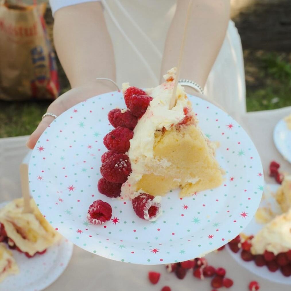 Sunlight glistens on a dreamy raspberry tower cake wrapped in a delicate white bow