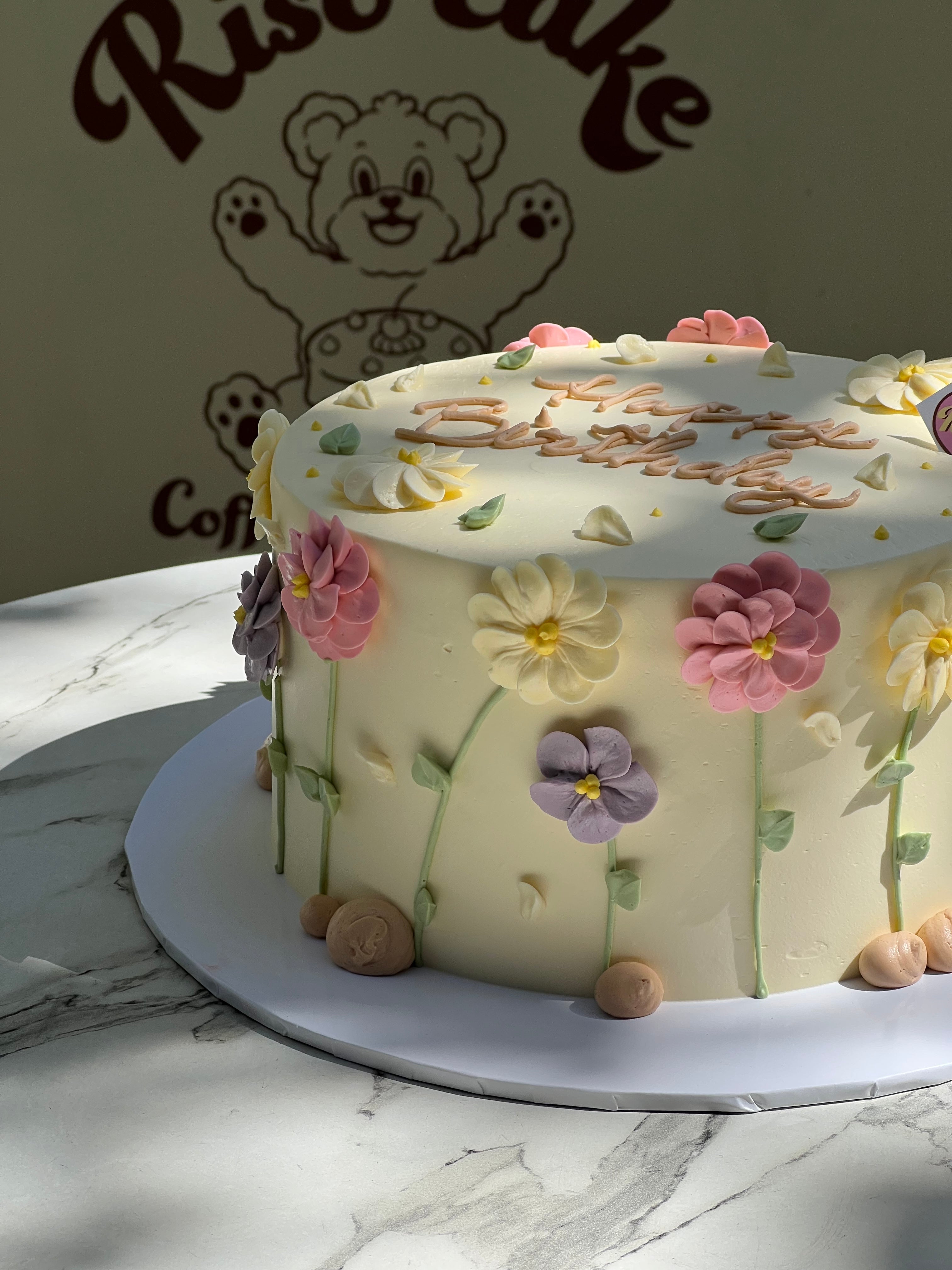 Close look at detailed daisy piping in various shades and leaf accents