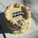 Top view of vintage cream birthday cake with piped border and pearl accents